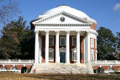 The Rotunda at the University of Virginia, featuring a circular structure with a domed roof and large white columns against a blue sky.