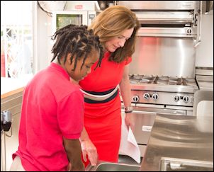 First Lady Dorothy McAulliffe and a student from St. Andrew's School check out the Class-A-Roll kitchen.
