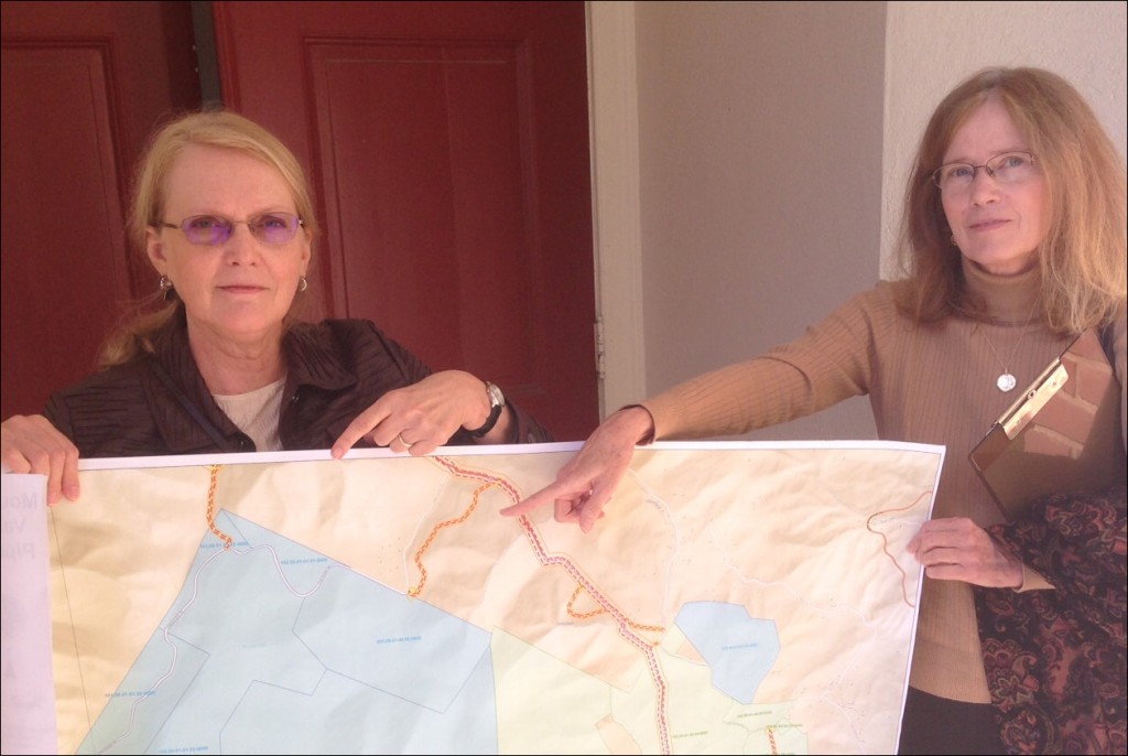 Elizabeth Terry Reynolds (left) and her sister Grace Terry show a map of family land in Roanoke County. The current iteration of the proposed Mountain Valley Pipeline route would cut through family land, and a construction access road would run through land held in a conservation easement (seen in blue).