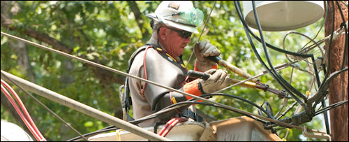 A crew man for Dominion Virginia Power works to restore electric power.