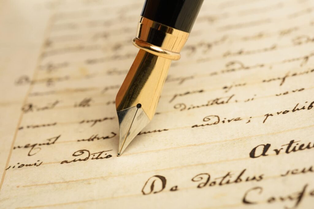 A close-up of a fountain pen poised over handwritten notes on aged paper.