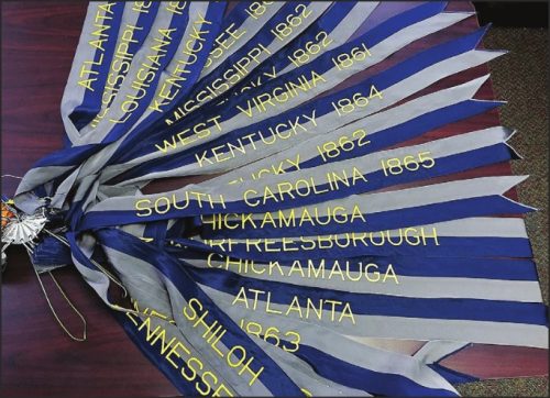 A collection of multi-colored battle streamers with gold lettering, representing various Civil War battles, laid out on a table.