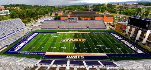Aerial view of James Madison University's football field, showcasing the field's markings, including the JMU logo at center field and 'DUKES' at the end zone.