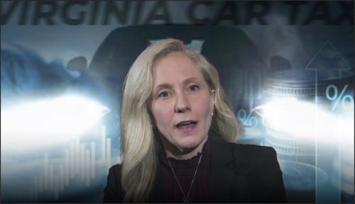 A woman speaking in front of a backdrop featuring car-related graphics and financial symbols, discussing car taxes in Virginia.