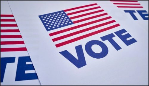 Four printed voting flyers featuring the word 'VOTE' alongside the American flag.