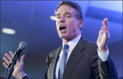 Senator Mark Warner speaking passionately at a podium, gesturing with his hands.