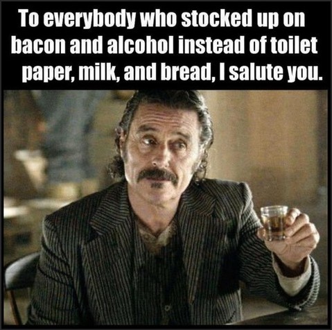 A man with a mustache holding a glass, with a humorous message about stocking up on bacon and alcohol instead of essential items.