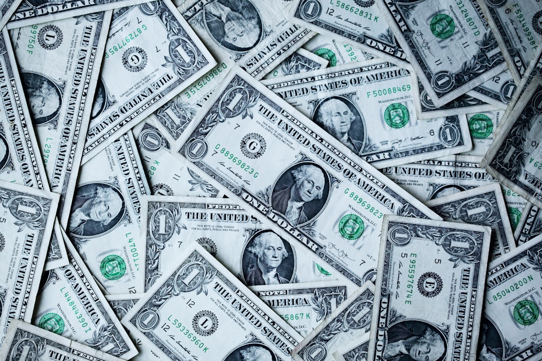 An array of one dollar bills scattered on a surface.