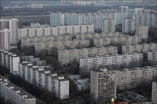 Aerial view of a large residential area featuring numerous high-rise apartment buildings and low-rise structures in a cityscape.