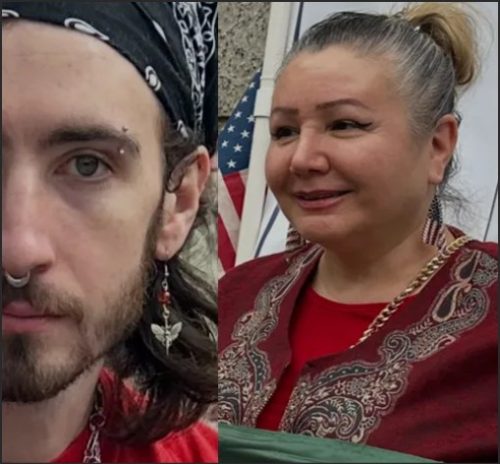 A close-up portrait of a young man with long hair, wearing a black bandana and multiple facial piercings, alongside a woman with tied-back hair, wearing red clothing and a patterned shawl, smiling in front of an American flag.