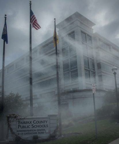 Foggy view of the Fairfax County Public Schools Administration Center with flags in front.